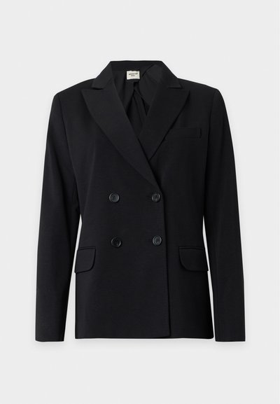 Blazer noir croisé à revers pointus, quatre boutons, deux poches avant à rabat et une poche poitrine sur fond uni.