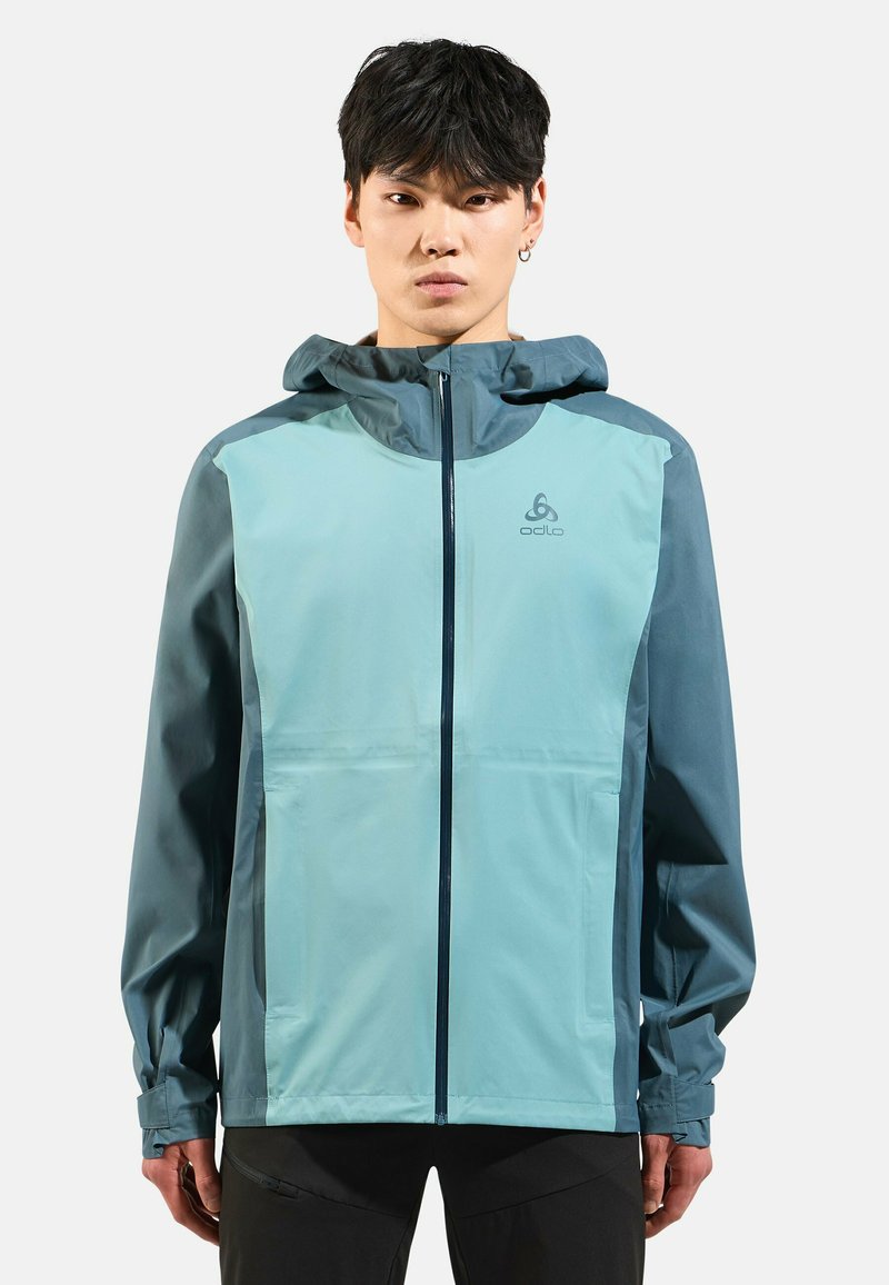 Men's lightweight jacket in teal and dark blue, featuring a zip front, hood, and contrasting color panels. Made from water-resistant material.