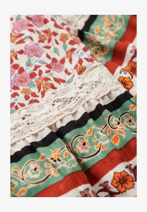 Bunt bedruckter Stoff mit floralen Mustern in Rot, Pink und Grün; verfügt über eine Spitze und geschichtete, rüschendetails.