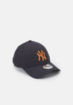 Navy blue cap made of cotton with a curved brim, featuring an embroidered orange logo on the front and eyelets for ventilation.