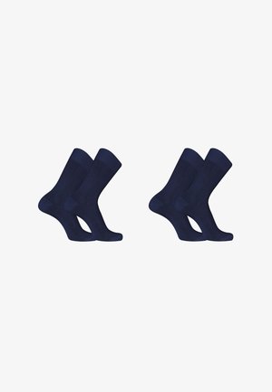 Deux paires de chaussettes bleu marine à hauteur de mollet disposées côte à côte sur un fond blanc.