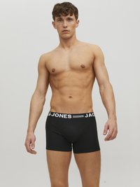 Schwarze Boxer-Briefs mit einem weißen elastischen Bund, der das Logo "JACK & JONES" trägt. Hergestellt aus dehnbarem Material, körpernahe Passform, glatte Textur.