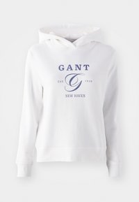 Hvid hættetrøje med en frontkangaroo lomme, der har marineblå tekst, som står "GANT EST. 1949 NEW HAVEN" og et stort, stiliseret "G" logo.