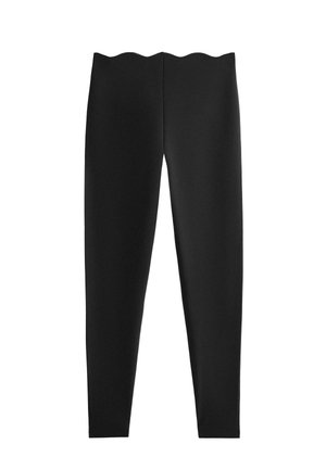 Black leggings with a fitted design and scalloped waistband, seamless appearance, displayed against a white background.