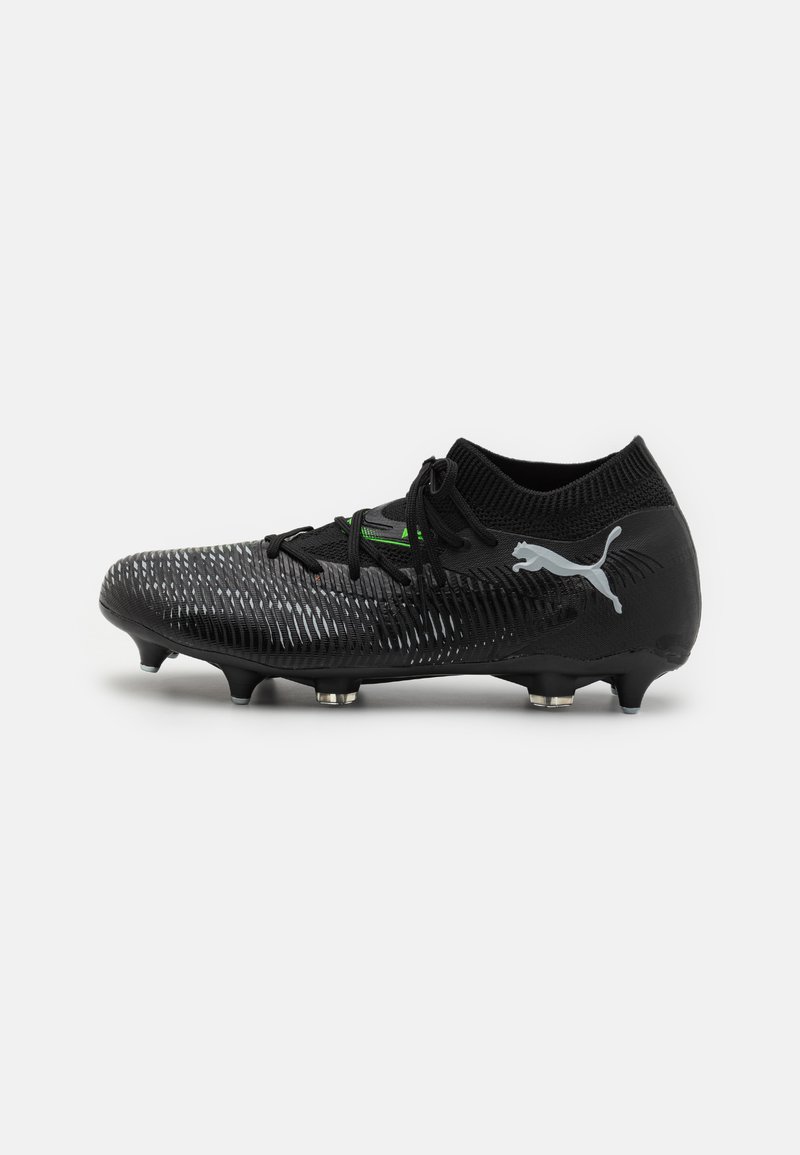 Black soccer cleat with a textured synthetic upper, green accents, lace closure, and conical studs for traction. Puma logo on the side.