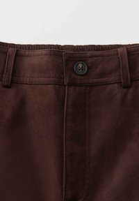 Braune Wildlederhose mit Knopfverschluss, Gürtelschlaufen und glatter Textur. Der Stoff hat einen leichten Glanz und eine saubere Nahtverarbeitung.