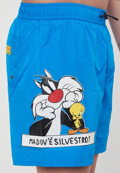 Blaue Badehosen aus glattem Material, mit einem großen Druck von Sylvester dem Kater und Tweety Bird, sowie einem Textbanner darunter.