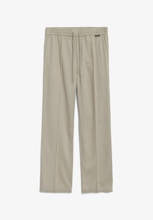 Lichtbeige, relaxte broek van zachte stof; heeft een elastische tailleband met een trekkoord en zijzakken.