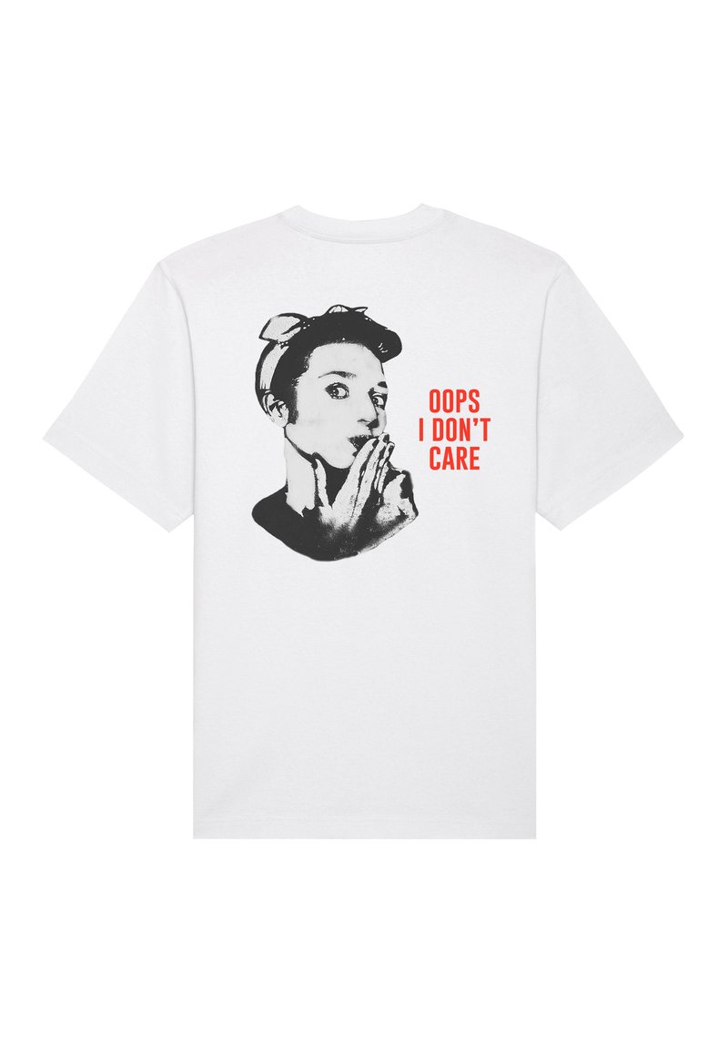 T-shirt en coton blanc avec un graphique noir représentant une personne portant un bandeau et le texte "OUPS, JE ME FOUS DE TOUT" en rouge gras, situé au dos.