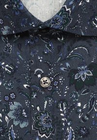 Chemise bleu foncé à motifs floraux avec un col et un bouton argenté centré sous le col.