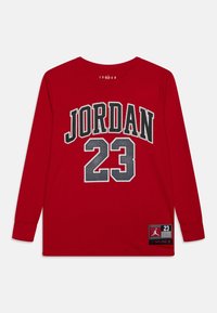 Rød langærmet skjorte med "JORDAN" og "23" i sort og sølv. Blødt bomuldsmateriale, rund halsudskæring og logopatch nederst til venstre.