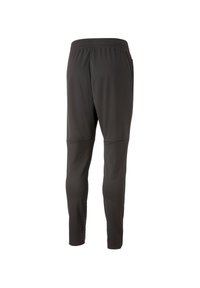 Pantaloni sportivi neri con tessuto testurizzato, gamba affusolata, vita elastica e dettagli di cucitura visibili.