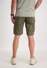 Pantaloni cargo verde oliva con due tasche laterali, realizzati in tessuto resistente, con una vestibilità comoda e orlo appena sopra il ginocchio.