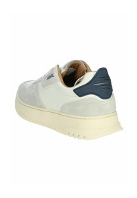 Sneaker da uomo con tomaia in pelle bianca e accenti in suede grigio, colletto imbottito color beige, linguetta sul tallone blu navy e suola in crema con texture.