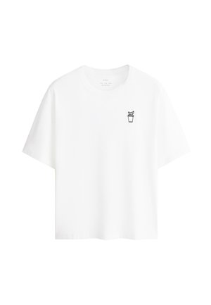 T-shirt blanc à manches courtes avec un petit dessin au trait noir d'une plante en pot sur la poitrine gauche.