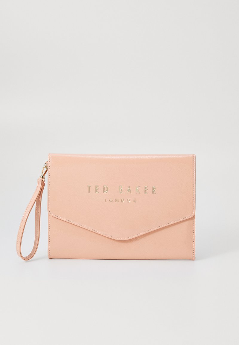 Pochette en simili cuir rose avec un logo doré, rabat en forme d'enveloppe et une dragonne. Texture lisse, design minimaliste.