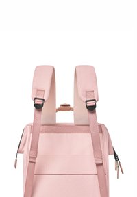 Sac à dos en tissu rose avec des bretelles réglables rembourrées, des accessoires noirs, une poche zippée et un design uni avec des accents minimalistes.
