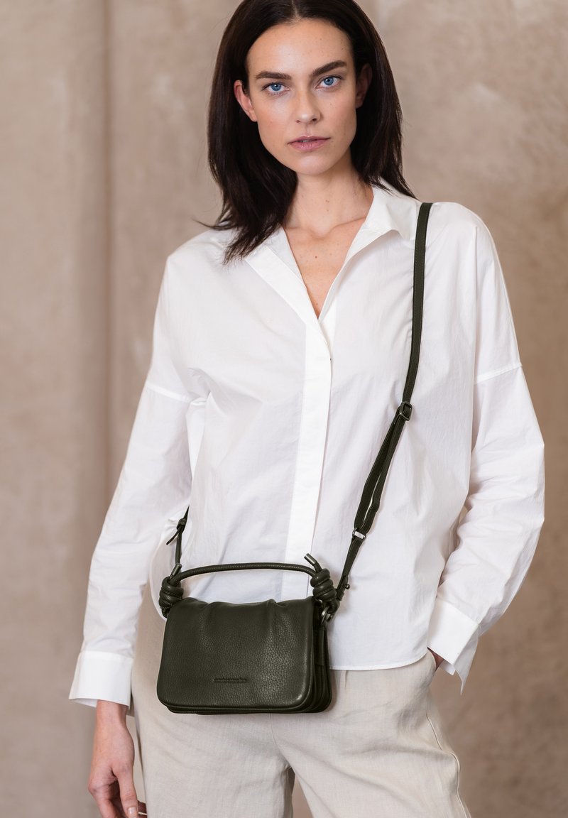 Borsa a tracolla in pelle verde scuro con finitura texturizzata, dettagli con manico annodato e tracolla regolabile. Design rettangolare compatto.