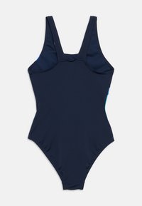 Ολόσωμο μαγιό σε ναυτικό μπλε, με απλό σχέδιο, φαρδιές τιράντες και λείο ύφασμα με ελαφριά γυαλάδα. Διακριτικές γαλάζιες λεπτομέρειες στα πλαϊνά.