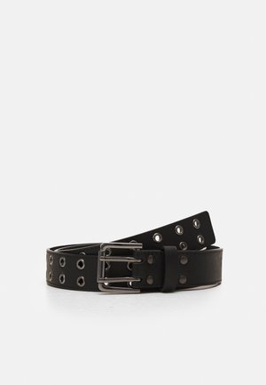 Cintura in pelle nera con fibbia doppia in argento e occhielli metallici distribuiti uniformemente lungo tutta la sua lunghezza, arrotolata su una superficie bianca.