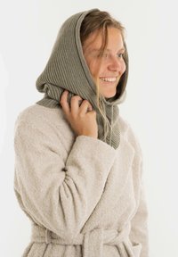 Grijze geribde gebreide hoodie valt over een lichtbeige textuurstof badjas, die zachte materialen en een ontspannen silhouet laat zien, met een gestrikt tailleband.