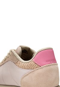 Helle rosa Sneakers aus Leder und Wildleder, mit einem strukturierten, beigen Paneel und einem rosa Akzent an der Ferse. Textil-Schnürsenkel und Nähte sind sichtbar.