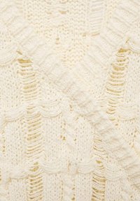 Sweter dzianinowy w kolorze kremowym, z teksturowanymi wzorami i otwartymi ściegami. Projekt zawiera dekolt w kształcie litery V oraz ściągacze. Miękki, przytulny materiał.