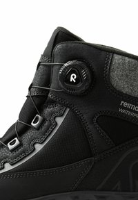 Wodoodporny czarny but turystyczny wykonany z teksturowanego syntetycznego materiału, system sznurowania z pokrętłem oraz gumowa podeszwa z wzorzystym bieżnikiem.