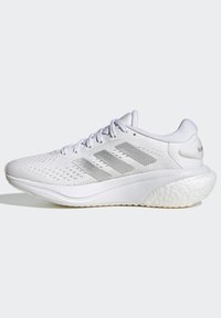 Witte sportieve schoen met een gemêleerd mesh bovenwerk, zilveren drie-strepen ontwerp, gevoerde zool en ronde hak. Beschikt over een vetersluiting en een gevoerde tong.