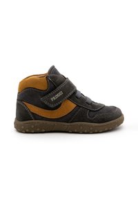 Scarpa alta in suede nera e marrone con cinturino in Velcro, punta arrotondata, cuciture grigie e suola in gomma testurizzata con motivi circolari.