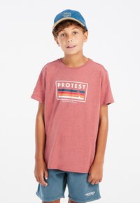 Rode katoenen t-shirt met het 'PROTEST'-logo en kleurrijke strepen. Gemaakt in combinatie met blauwe shorts en een blauwe pet met het woord 'PROTEST'.
