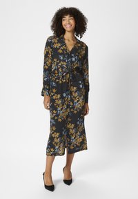 Robe à imprimé floral avec manches longues, base noire et design jaune-bleu. Dotée d'une taille nouée et d'un ourlet mi-long, tissu doux au toucher.