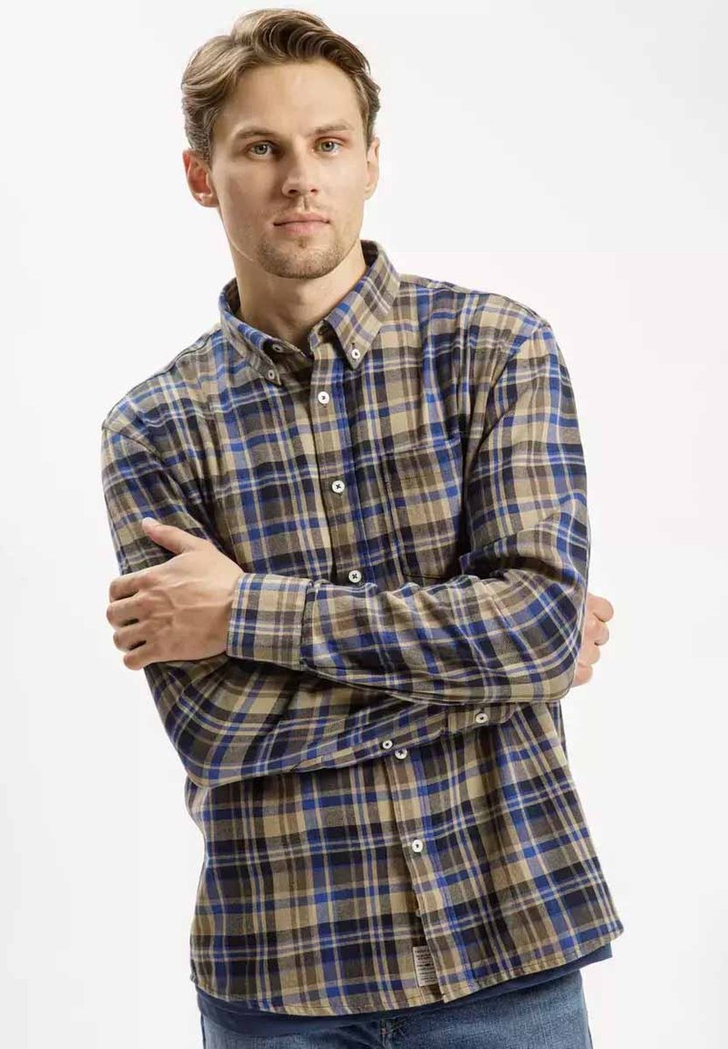 Brązowa i niebieska koszula w kratę zapinana na guziki z długimi rękawami, wykonana z materiału o miękkiej teksturze; posiada klasyczny kołnierzyk i zapięcie na guziki.