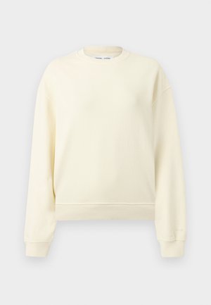 Sweat-shirt à col rond beige crème à manches longues avec poignets et ourlet côtelés, présenté sur un fond gris clair uni.