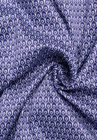 Marineblauwe stof met een herhalend patroon van witte en lichtblauwe druppels, met een gladde textuur en een lichte glans.