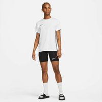 T-shirt blanc à manches courtes de Nike avec des accents latéraux noirs et un logo, associé à des shorts de compression noirs, des chaussettes blanches et des sandales à glissière noires.