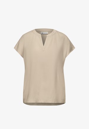 Blouse beige à manches courtes avec un col rond fendu et des détails subtils de coutures, portant l'étiquette "Street One" à l'intérieur du col.