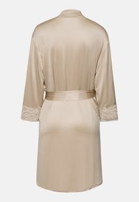 Abito in satin beige con colletto a scialle, maniche a tre quarti con bordi in pizzo e cintura coordinata. Texture liscia in tutto l'abito.