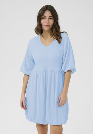Abito di un blu chiaro, con una texture morbida, scollatura a V, maniche a sbuffo e gonna arricciata, che creano una vestibilità rilassata e un orlo arrotondato.