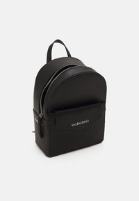 Black leather backpack with a rounded shape, featuring two zippered compartments and a front pocket with a subtle logo. Smooth texture.