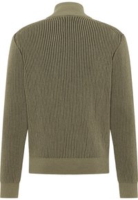 Olivgrön ribbad tröja med hög krage, med vertikal stickad struktur och enfärgade mudd. Tillverkad av mjukt, texturerat tyg.