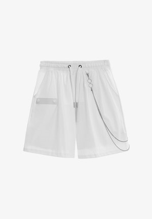 Pantalones cortos blancos con cintura elástica y cordón, bolsillos laterales, bolsillo con solapa abotonada a la izquierda y cadena decorativa plateada en el lado derecho.