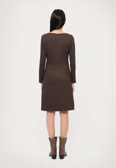 Brown, mid-length dress with long sleeves, a fitted bodice, and a flared skirt. Texture appears woven; paired with brown ankle boots.