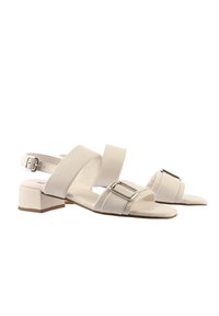 Weiße Blockabsatzsandalen mit breiten Riemen und silberner Schnallenakzent. Glatte Textur mit runder Zehenform und verstellbarem Knöchelriemen.