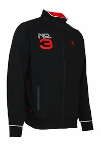 Svart zip-up jacka med hög krage, med röda detaljer och "NR. 3" i fet stil. Inkluderar en ficka med dragkedja på sidan och ribbade ärmslut.