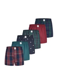 Zes paar herenboxershorts in verschillende kleuren en patronen, waaronder ruitpatroon, effen teal, effen bordeauxrood en marineblauw met kleine witte beren.