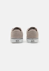 Beige semskinn-sneakers med hvit gummisåle og svarte detaljer. Har et subtilt "66/99" preget design over hælen.