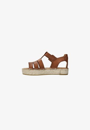 Brown leather sandal with open design, featuring multiple straps, a textured espadrille sole, and a velcro strap for fastening.