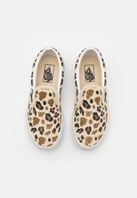 Scarpe slip-on con stampa leopardata realizzate in materiale di tela beige, con dettagli dorati, suola in gomma bianca e bande elastiche laterali per una facile calzata.
