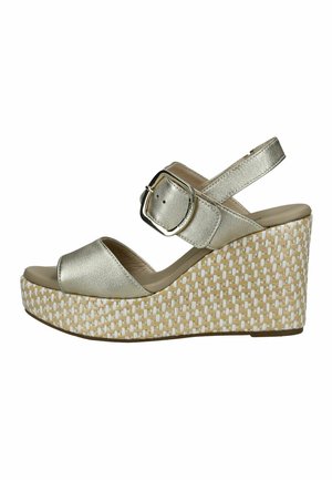 Sandaal met sleehak met metalen gouden bandjes, grote vierkante gesp en een gevlochten beige-witte plateauzool.